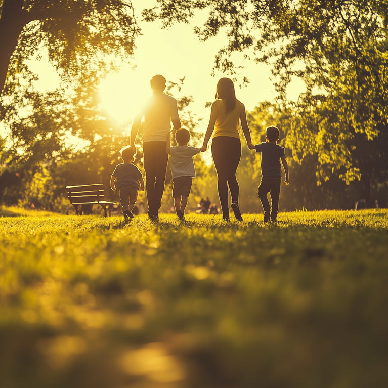 Two parents and their three children walk in a park on a sunny evening