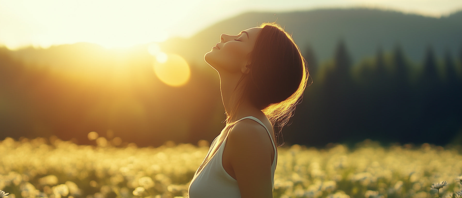 A woman breathes in the clean air in a meadow at sunset